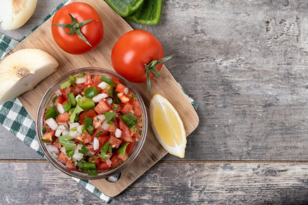 Traditional Mexican Pico de Gallo sauce in bowl on wooden table